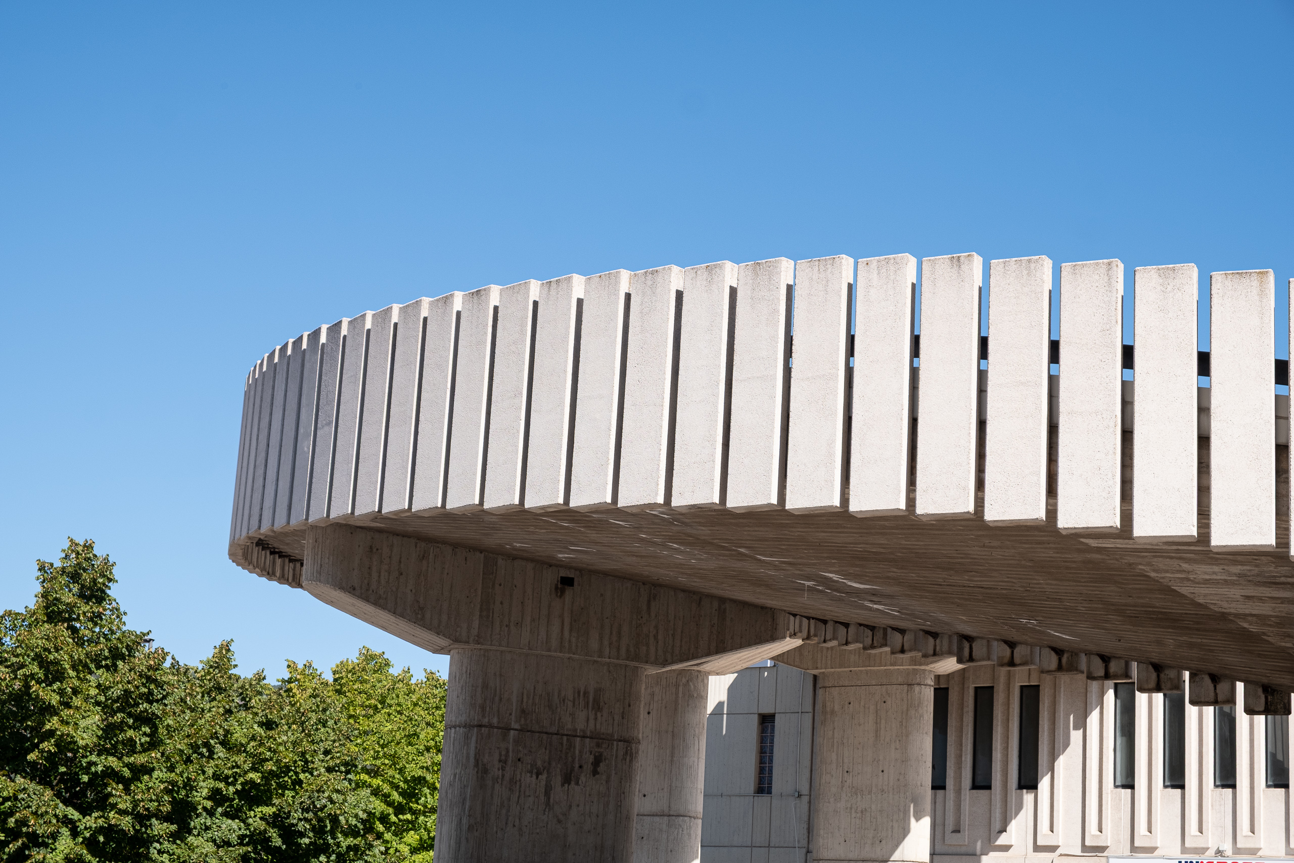 Betonarchitektur mit runder Auskragung unter blauem Himmel